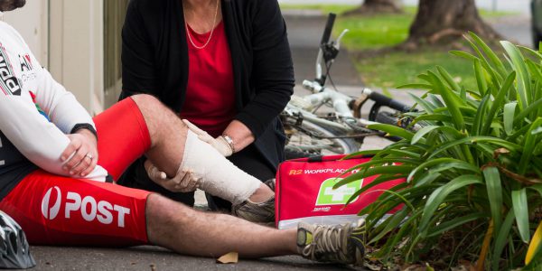 First-aid trained bystander administers first aid to an injured cyclist